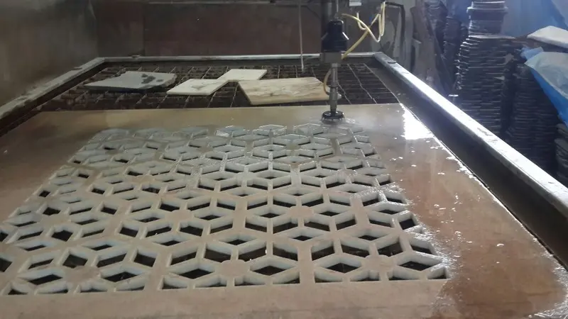 CNC waterjet cutting a pattern in marble